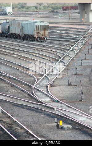 Lokomotive ferngesteuertes Fahrerhaus unbesetzt Eisenbahnbahnhof mit Nebengleisen und Umschaltern und Motoren und Autos und Reparatureinrichtungen in Utah Schild Stockfoto