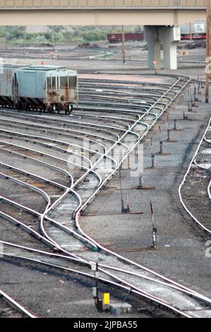 Lokomotive ferngesteuertes Fahrerhaus unbesetzt Eisenbahnbahnhof mit Nebengleisen und Umschaltern und Motoren und Autos und Reparatureinrichtungen in Utah Schild Stockfoto