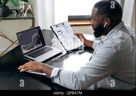 Erfolgreicher Krypto-Trader-Investor-Broker, der Laptop für die Kryptowährung-Finanzmarktanalyse verwendet, Kryptowährung kauft oder verkauft und Finanzdiagramme auf dem Bildschirm analysiert Stockfoto