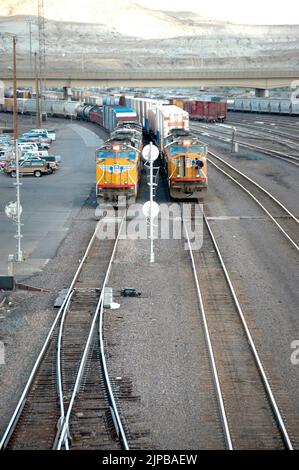 Lokomotive ferngesteuertes Fahrerhaus unbesetzt Eisenbahnbahnhof mit Nebengleisen und Umschaltern und Motoren und Autos und Reparatureinrichtungen in Utah Schild Stockfoto