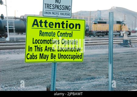 Lokomotive ferngesteuertes Fahrerhaus unbesetzt Eisenbahnbahnhof mit Nebengleisen und Umschaltern und Motoren und Autos und Reparatureinrichtungen in Utah Schild Stockfoto