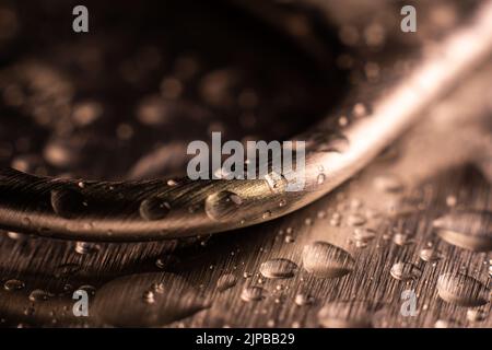 Eine Aufnahme von Wassertropfen im Vollformat auf der Metalloberfläche Stockfoto