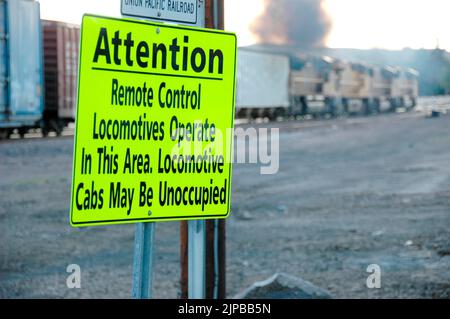 Lokomotive ferngesteuertes Fahrerhaus unbesetzt Eisenbahnbahnhof mit Nebengleisen und Umschaltern und Motoren und Autos und Reparatureinrichtungen in Utah Schild Stockfoto