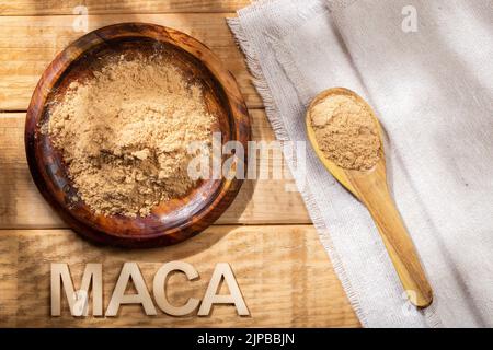 Maca-Pulver, in Holzschale auf dem Tisch, Nährstoff aus Peru. Stockfoto