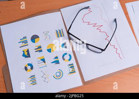Präsentationsvorlage mit Business-Charts und Brille. Hintergrund mit Business Elements Figuren und Brille. Ordner, Papiere mit Grafiken und Gläser auf einem Holztisch. Hochwertige Fotos Stockfoto