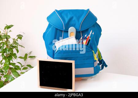 Schulrucksack auf dem Tisch. Vorbereitung auf die Schule Stockfoto