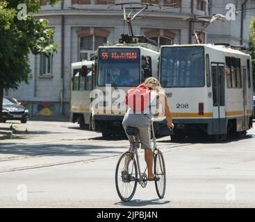 Bukarest, Rumänien - 04. August 2022: An einem sehr heißen Tag fährt ein Mann auf einem Boulevard mit dem Fahrrad. Dieses Bild ist nur für redaktionelle Zwecke bestimmt. Stockfoto