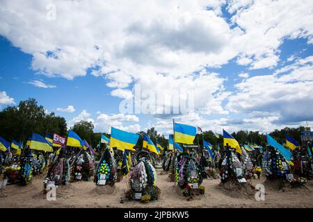 Kiew, Ukraine. 18.. Juli 2022. Gräber ukrainischer Soldaten, die im Krieg mit Russland auf einem Friedhof in Kiew getötet wurden. Ein Soldat wurde in einer Schlacht in der Ostukraine infolge der russischen Invasion in der Ukraine getötet. Die Angehörigen des Soldaten halten seinen Namen und sein Foto geheim, weil das Leben seines Vaters in einem Teil der von russischen Truppen besetzten Region Luhansk in Gefahr sein wird und wenn die Besatzungsbehörden herausfinden, dass sein Sohn in der ukrainischen Armee gekämpft hat, kann der Vater verhaftet und gefoltert werden. (Foto von Oleksii Chumachenko/SOPA Images/Sipa USA) Quelle: SIPA USA/Alamy Live News Stockfoto