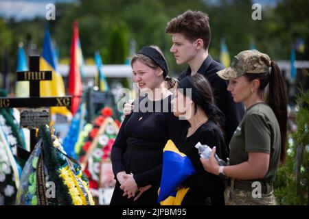 Kiew, Ukraine. 18.. Juli 2022. Angehörige reagieren emotional während der Beerdigungszeremonie eines ukrainischen Soldaten mit dem Spitznamen „Fanat“ in Kiew. Ein Soldat wurde in einer Schlacht in der Ostukraine infolge der russischen Invasion in der Ukraine getötet. Die Angehörigen des Soldaten halten seinen Namen und sein Foto geheim, weil das Leben seines Vaters in einem Teil der von russischen Truppen besetzten Region Luhansk in Gefahr sein wird und wenn die Besatzungsbehörden herausfinden, dass sein Sohn in der ukrainischen Armee gekämpft hat, kann der Vater verhaftet und gefoltert werden. (Bild: © Oleksii Chumachenko/SOPA Images via ZUMA Press Wire) Stockfoto