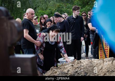 Kiew, Ukraine. 18.. Juli 2022. Mutter trauert in der Nähe des Grabes während der Beerdigung eines ukrainischen Soldaten mit dem Spitznamen „Fanat“ in Kiew. Ein Soldat wurde in einer Schlacht in der Ostukraine infolge der russischen Invasion in der Ukraine getötet. Die Angehörigen des Soldaten halten seinen Namen und sein Foto geheim, weil das Leben seines Vaters in einem Teil der von russischen Truppen besetzten Region Luhansk in Gefahr sein wird und wenn die Besatzungsbehörden herausfinden, dass sein Sohn in der ukrainischen Armee gekämpft hat, kann der Vater verhaftet und gefoltert werden. (Bild: © Oleksii Chumachenko/SOPA Images via ZUMA Press Wire) Stockfoto