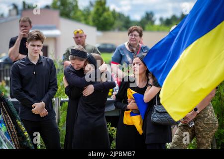 Kiew, Ukraine. 18.. Juli 2022. Angehörige reagieren emotional während der Beerdigungszeremonie eines ukrainischen Soldaten mit dem Spitznamen „Fanat“ in Kiew. Ein Soldat wurde in einer Schlacht in der Ostukraine infolge der russischen Invasion in der Ukraine getötet. Die Angehörigen des Soldaten halten seinen Namen und sein Foto geheim, weil das Leben seines Vaters in einem Teil der von russischen Truppen besetzten Region Luhansk in Gefahr sein wird und wenn die Besatzungsbehörden herausfinden, dass sein Sohn in der ukrainischen Armee gekämpft hat, kann der Vater verhaftet und gefoltert werden. (Bild: © Oleksii Chumachenko/SOPA Images via ZUMA Press Wire) Stockfoto