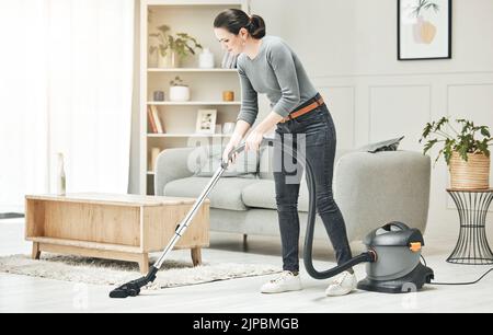 Staubsaugen, Putzen und Hausarbeiten von einer Mutter, Hausfrau oder Freundin mit einem Staubsauger. Bleiben Sie zu Hause Mama, Zimmermädchen oder Haushälterin tun Stockfoto