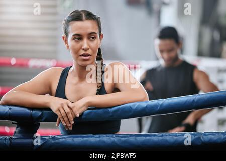 Fit, aktiv und müde Boxer Pause machen, Ruhe und Atmung nach dem Training, Training und Bewegung mit Boxtrainer im Ring. Sportlich, sportlich oder Stockfoto