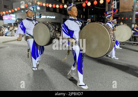 Tokushima, Japan - 12. August 2022: Trommler mit traditionellen japanischen Taiko-Trommeln in einer Straßenprozession beim Awaodori-Festival Stockfoto