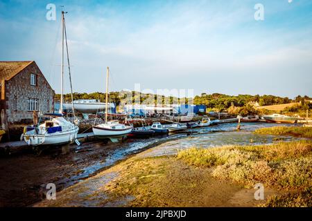 Ebbe auf dem Yarmouth Marina-Bootshof auf der Isle of Wight mit den Yachten, die bei Ebbe auf dem Boden liegen Stockfoto