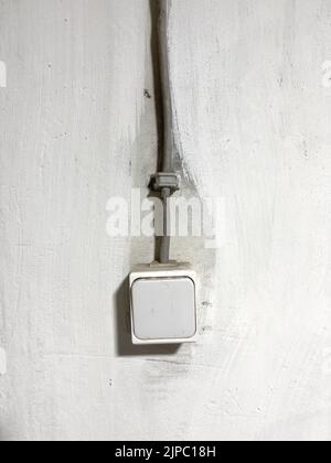Die vertikale Nahaufnahme eines alten Lichtschalters an der Wand Stockfoto