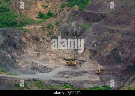 Kleiner Steinbruch mit Bergbaumaschinen in bergigen Gebieten Stockfoto