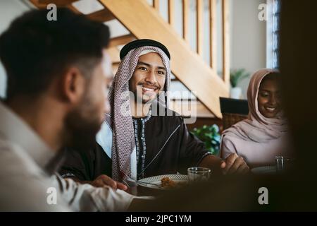 Muslimischer, arabischer und islamischer Mann, der eine Mahlzeit für eid, ramadan oder ein Fastenbrechen mit der Familie genießt, während er Religion, heilige Kultur und islamischen Glauben feiert Stockfoto