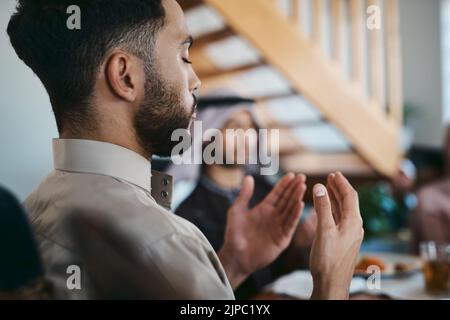 Muslim, Beten und Religion, während Sie mit der Familie sitzen und ein dua oder Gebet sprechen, bevor Sie während des heiligen Monats Ramadan das Fasten brechen. Religiöser Mensch Stockfoto