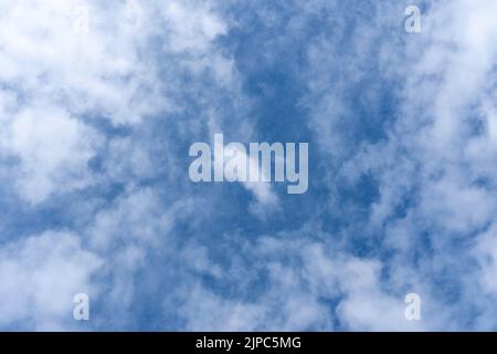 Blauer Himmel Hintergrund mit weißen flauschigen Cumulus Wolken. Panorama von weißen, flauschigen Wolken am blauen Himmel. Wunderschöner, riesiger blauer Himmel mit erstaunlichen verstreuten Stockfoto