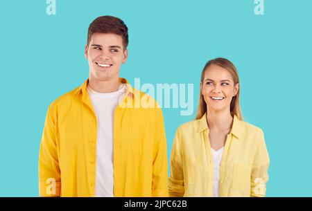 Junge kaukasische Mann und Frau lächeln und sich nicht umdrehen und einander anguhen, stehen im Studio Stockfoto