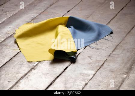 Die Nationalflagge der Ukraine auf den Boden eines Hauses in der Ukraine geworfen, eine Tragödie in jedem Haus im Land der Ukraine 2022 Stockfoto