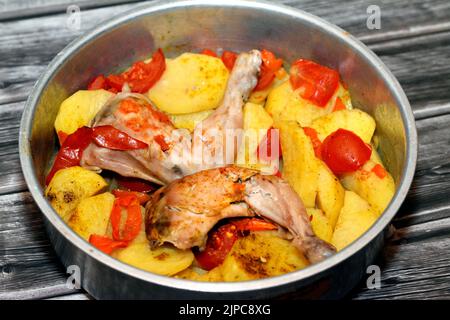 Hähnchenschenkel und Oberschenkel mit Kartoffelscheiben, Tomaten und Zwiebeln mit im Ofen gebackenen, im Ofen gebackenen Gewürzen, selektiver Fokus auf ägyptische Speisen c Stockfoto