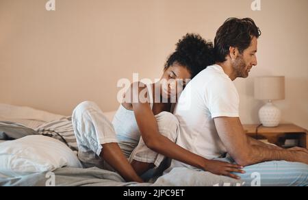 Traurig, frustriert und unglücklich Mann und Frau umarmten sich nach einer Trennung in ihrem Schlafzimmer. Verärgert, verärgert und deprimiert Mann bekommen Unterstützung mit seiner Frau Stockfoto