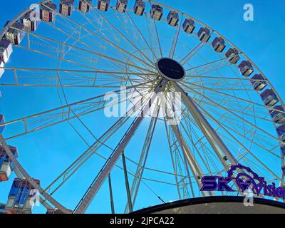 Zandvoort, Niederlande - August 12. 2022: Nahaufnahme des Riesenrads in der niederländischen Küstenstadt mit nachmittäglicher Sonnenbeleuchtung, blauem Sommerhimmel Stockfoto