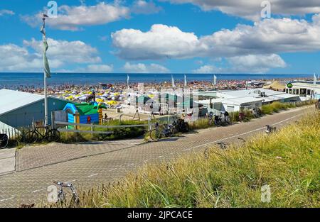 Zandvoort, Niederlande - August 12. 2022: Blick von den Dünen auf den überfüllten holländischen Nordseestandstrand am sonnigen Sommerwochenende Stockfoto