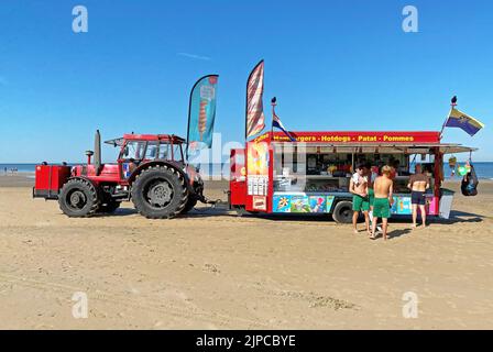 Zandvoort, Niederlande - August 12. 2022: Lebensmittelversorgung für Strandbesucher - typischer mobiler Imbissstand und Küchentrailer, der von einem Traktor bei dutch gezogen wird Stockfoto