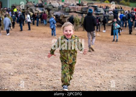 Puckapunyal, Australien, 17. August 2022. Die junge Maddie aus Puckapunyal prüft, was ihr Vater in ihrer eigenen Armeeuniform während einer Armee-Feuerkraftdemonstration für Gäste und Familien A Puckapunyal Range in Victoria macht. Quelle: Michael Currie/Speed Media/Alamy Live News Stockfoto