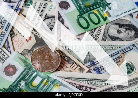 Bitcoin- und Dollar- und Euro-Scheine. Das BTC-Marktsymbol Kryptowährung fällt über dem US-Dollar und dem Euro. Bitcoin auf Papier Währung. Stockfoto