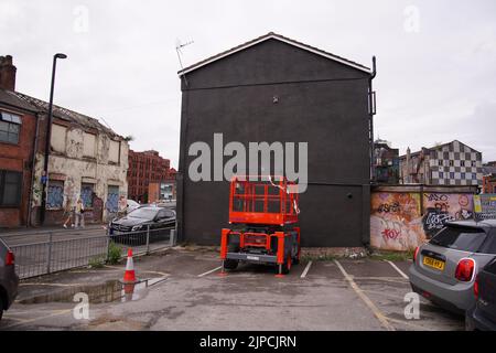 Die jetzt leere Wand an der Seite eines Gebäudes in der Port Street, Manchester, wo ein Wandgemälde des Joy Division-Sängers Ian Curtis vom Graffiti-Künstler Akse im Jahr 2020 entstand. Rapper Aitch sagte, er versuche, die Situation „pronto“ zu beheben, nachdem ein Werbekunstwerk für sein demnächst erscheinendes Debütalbum über das beliebte Wandgemälde von Curtis gemalt wurde, das ursprünglich für das Musikevent „Manchster Mental Health“, Headstock, geschaffen wurde. Bilddatum: Mittwoch, 17. August 2022. Stockfoto