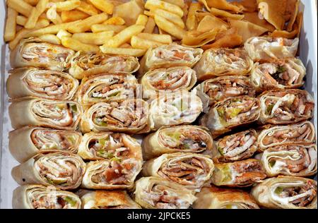 Syrisches Rezept Küche Hintergrund, eine Box voller Stücke von Huhn Shawerma oder Shawarma Tortilla Wrap mit Zwiebeln, Tomaten, Salat und Knoblauchsauce in S Stockfoto