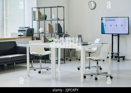 Horizontales Bild eines modernen Büros mit Tisch in der Mitte für Geschäftstreffen Stockfoto