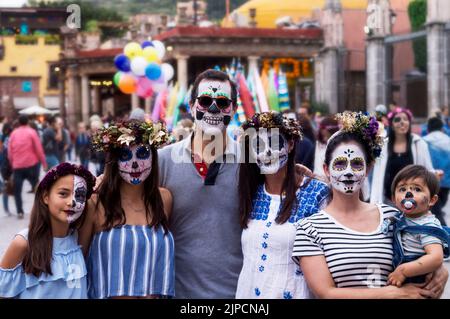 Eine wunderschöne Aufnahme einer Familie mit Totenkopf-Make-up, die den Tag der Toten feiert Stockfoto