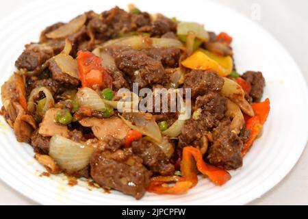 Ein Teller mit chinesischen Lebensmitteln Küche von gegrilltem Rindfleisch roten Fleischstücken mit Öl, Pilz, Gemüse, Erbsen, Karotten, Bunte Paprika, Glocke, Chili, o Stockfoto