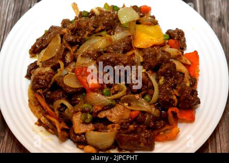 Ein Teller mit chinesischen Lebensmitteln Küche von gegrilltem Rindfleisch roten Fleischstücken mit Öl, Pilz, Gemüse, Erbsen, Karotten, Bunte Paprika, Glocke, Chili, o Stockfoto