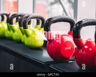 Reihen von schweren Metallhanteln auf dem Gestell im Fitnessstudio oder Club. Krafttrainingsgeräte. Sport- und Gesundheitskonzept. Stockfoto