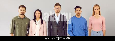 Team von jungen Geschäftsleuten mit ernsthaften Mimik im Studio Stockfoto
