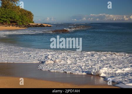 Ein wunderschönes Meer mit schäumenden Wellen, die am Sandstrand in Hawaii krachen Stockfoto