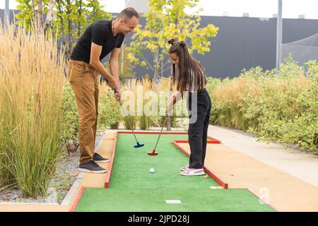 Vater und Tochter spielen Mini Golf Stockfoto