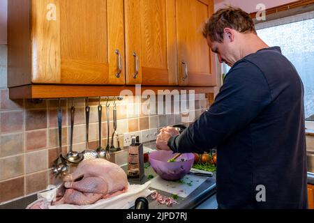 Ein junger Mann, der das Weihnachtsessen vorbereitet, Sussex, Großbritannien Stockfoto