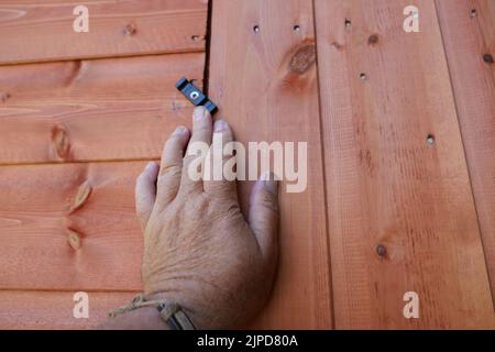 POV Hand öffnen oder schließen eine neue Holzschuppen Tür Stockfoto