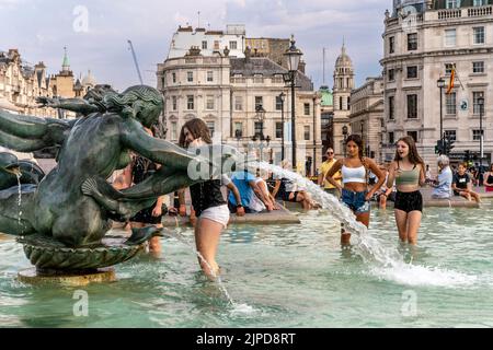 Junge Menschen kühlen sich während des heißesten Tages ab, der je in der Hauptstadt London aufgezeichnet wurde, in den Fountains am Trafalgar Square. Stockfoto