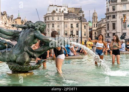 Junge Menschen kühlen sich während des heißesten Tages ab, der je in der Hauptstadt London aufgezeichnet wurde, in den Fountains am Trafalgar Square. Stockfoto