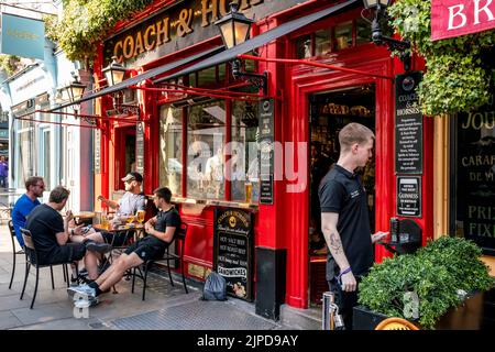 Menschen, die vor dem Coach and Horses Pub in Covent Garden, London, sitzen. Stockfoto