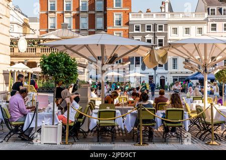 Menschen, die in einem Restaurant auf der Piazza, Covent Garden, London, Großbritannien, essen. Stockfoto