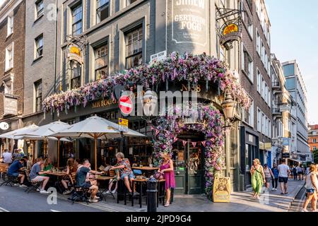 Personen, die vor Mr Fogg's Tavern in St Martin's Lane, London, Großbritannien, sitzen. Stockfoto